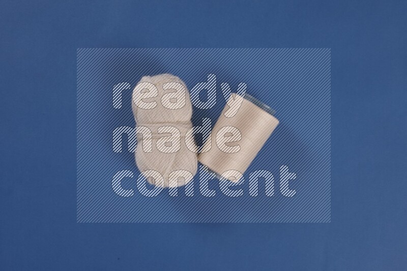 مجموعة من أدوات الخياطة والتفصيل بيضاء اللون على خلفية زرقاء