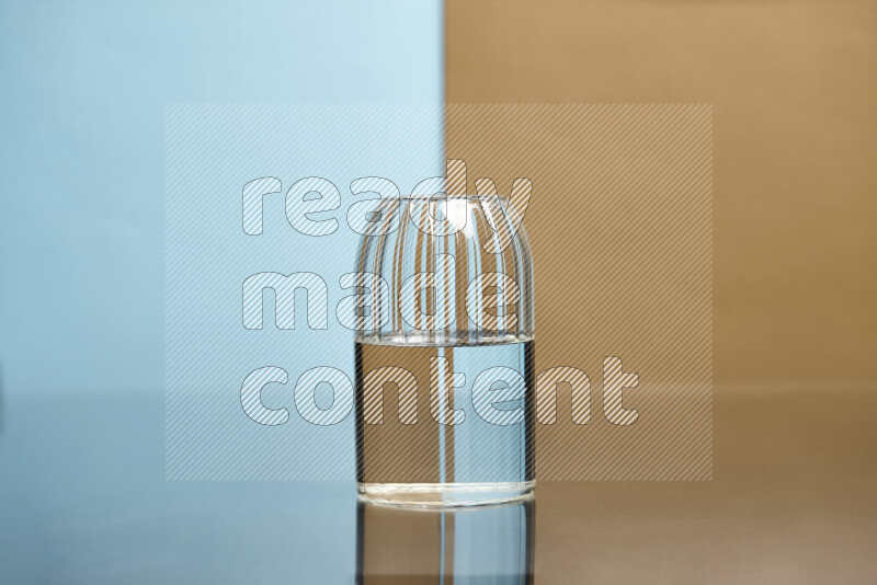 The image features a clear glassware filled with water, set against light blue and beige background