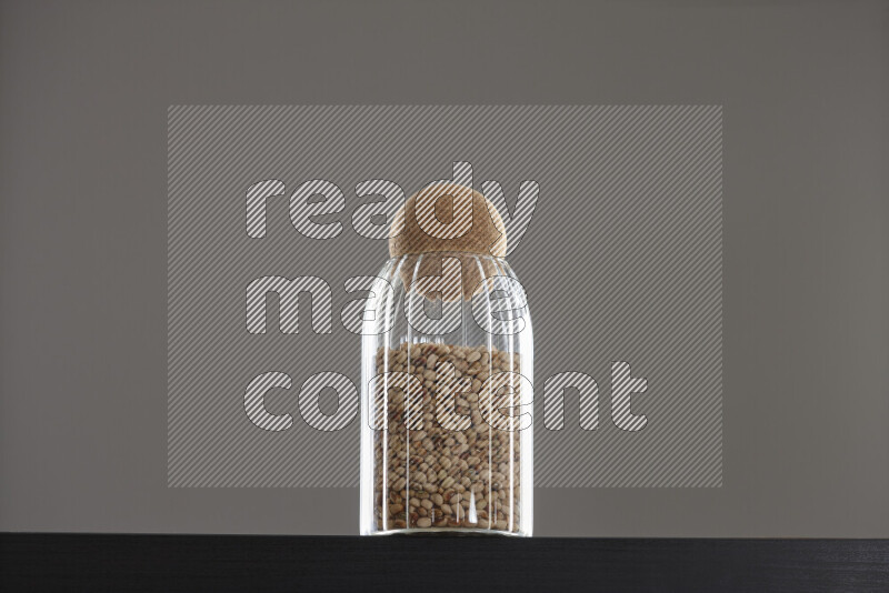 Black-eyed peas in a glass jar on black background