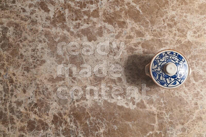 A multicolored pottery pot on beige marble background