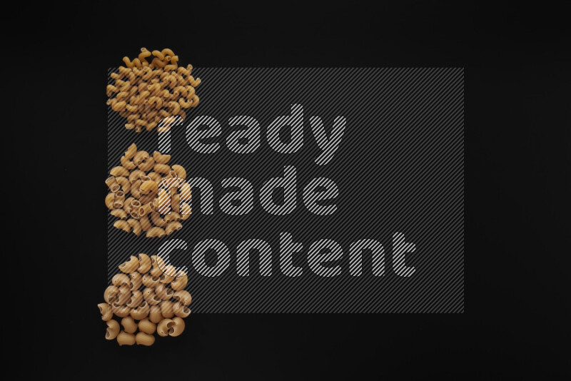 Different pasta types in 3 bunches on black background
