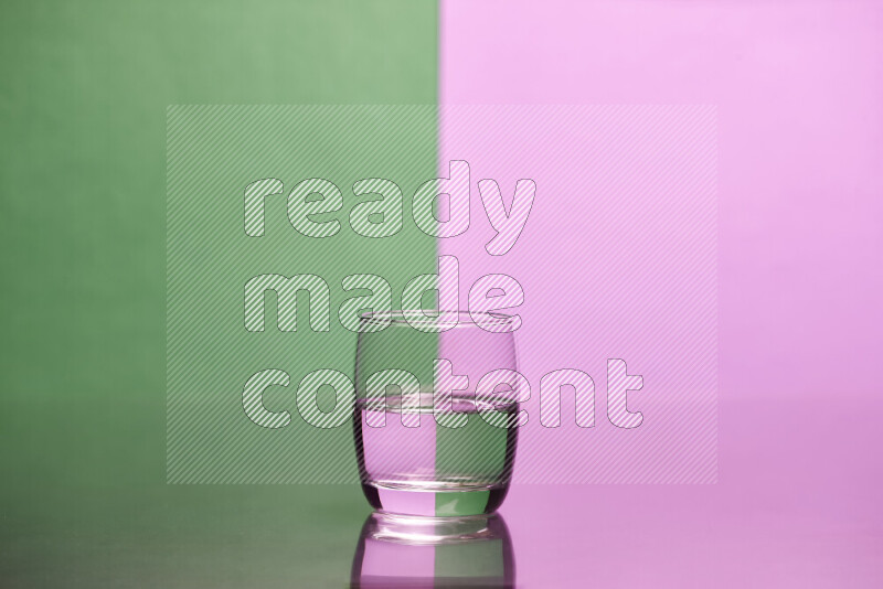 The image features a clear glassware filled with water, set against green and light purple background