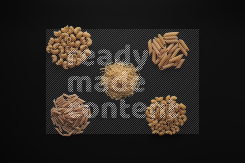 Different pasta types in bunches on black background