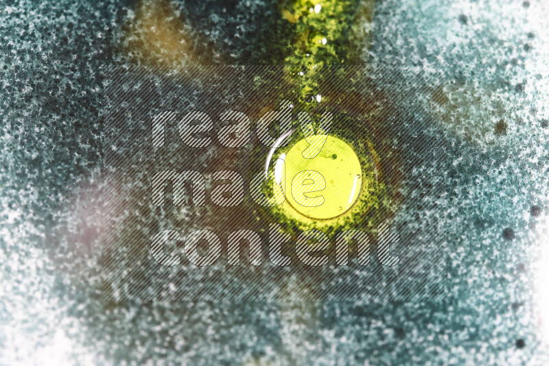 Close-ups of abstract green and yellow watercolor drops on oil Surface on white background
