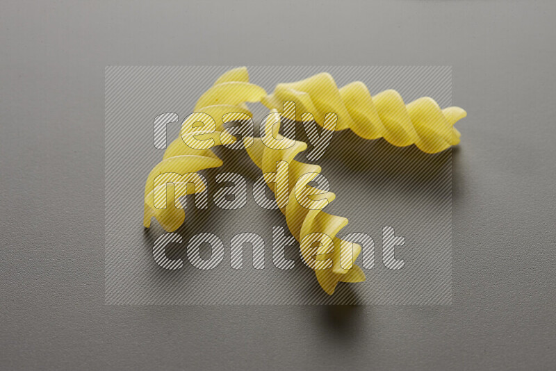 Fusilli pasta on grey background