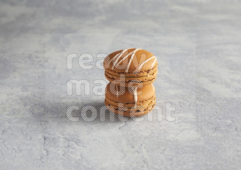 45º Shot of two Brown Irish Cream macarons  on white  marble background