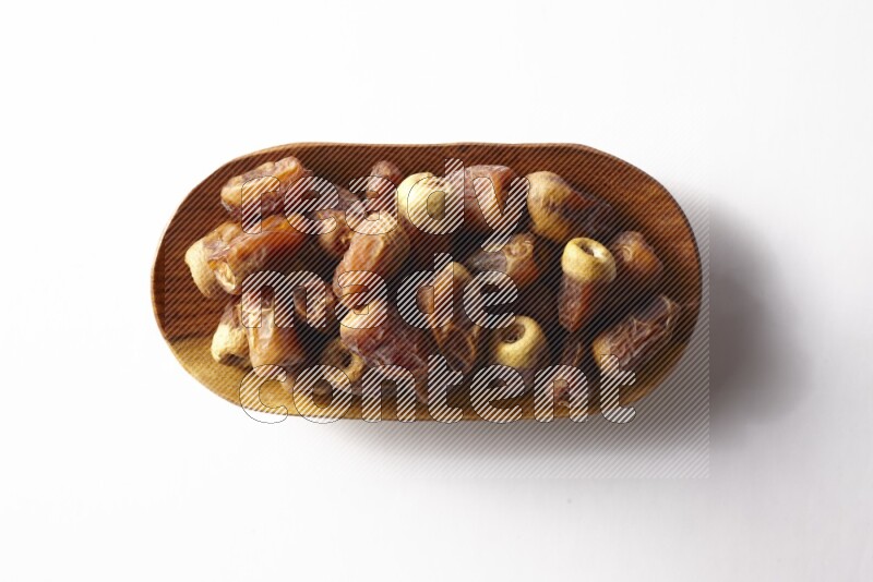 Dates in a wooden plate on white background