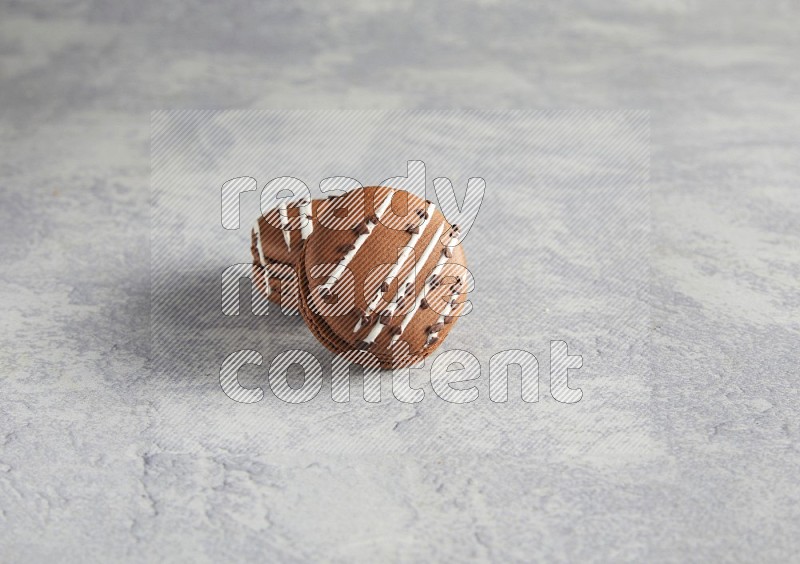45º Shot of two Brown white marbleChocolate Caramel macarons  on white  marble background