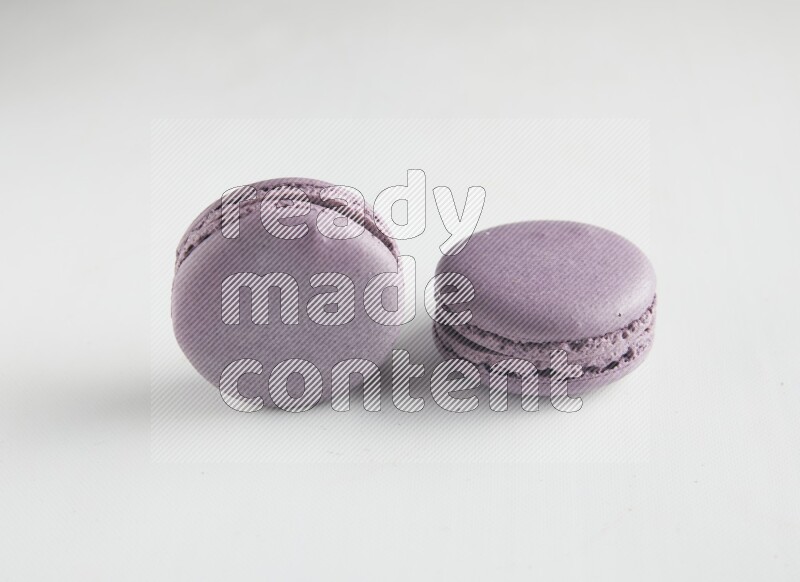 45º Shot of two Purple Blueberry macarons on white background