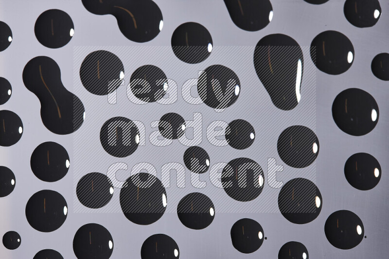 Close-ups of abstract black paint droplets on the surface