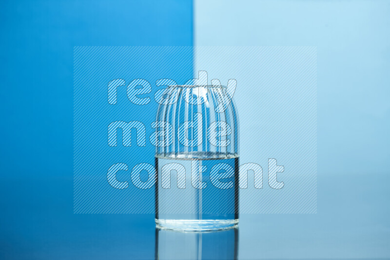 The image features a clear glassware filled with water, set against blue and light blue background