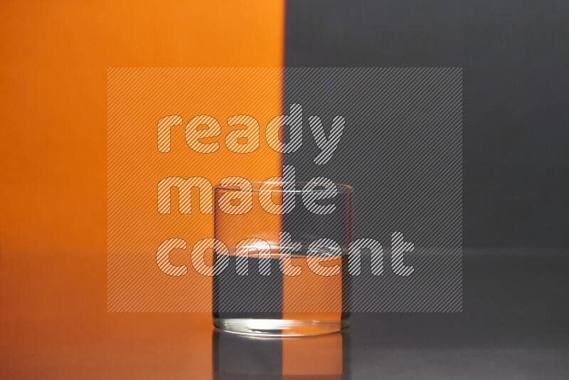 The image features a clear glassware filled with water, set against orange and black background