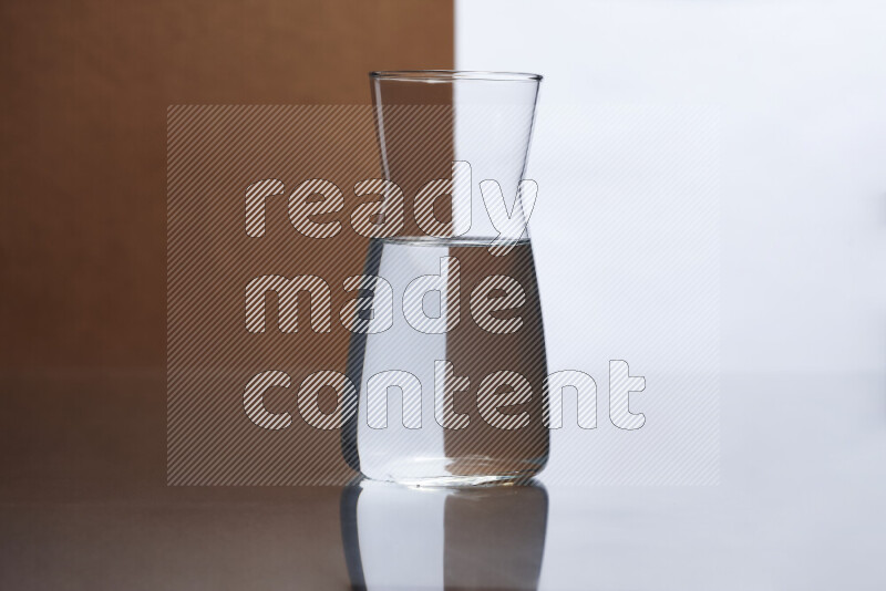 The image features a clear glassware filled with water, set against white and brown background