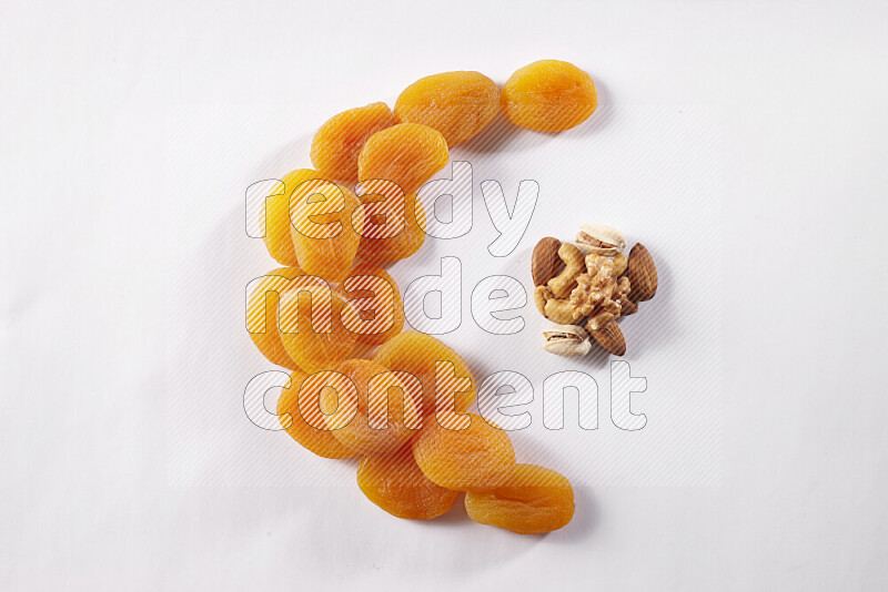 Dried apricots in a crescent shape on white background