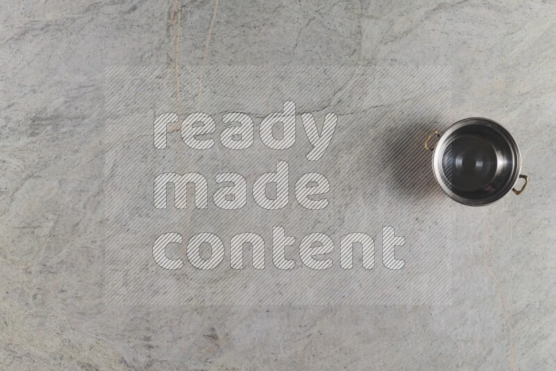 وعاء نحاسي صغير على خلفية من الرخام الرمادي