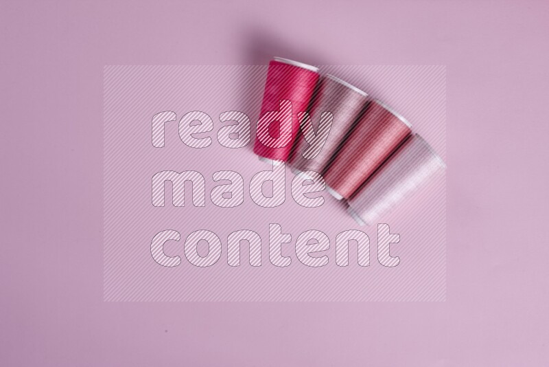 مجموعة من أدوات الخياطة والتفصيل زهرية اللون على خلفية زهرية