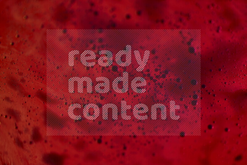 Close-ups of abstract blue watercolor drops on oil Surface on red background