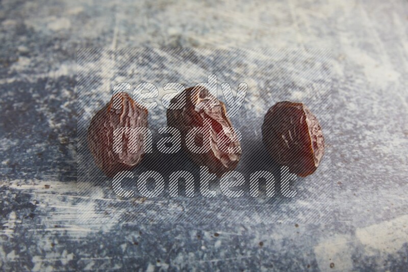 three madjoul dates on a rustic blue backround
