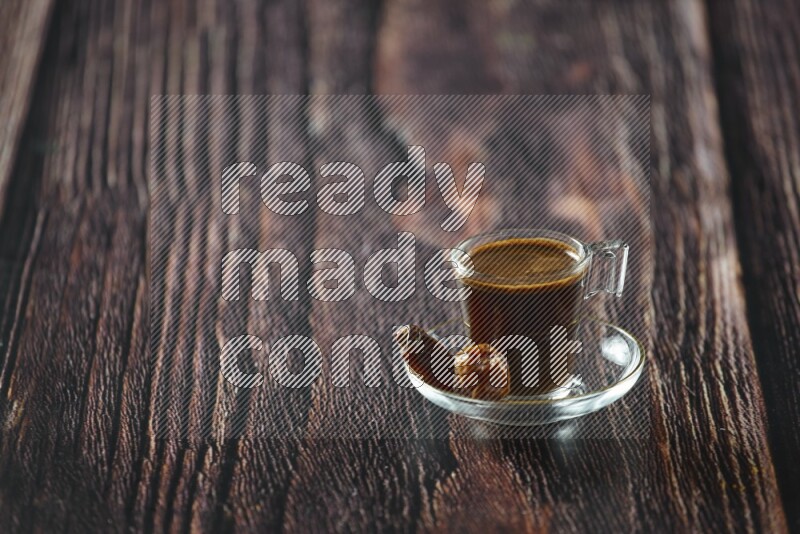 A coffee glass cup with dates and tea on wooden background