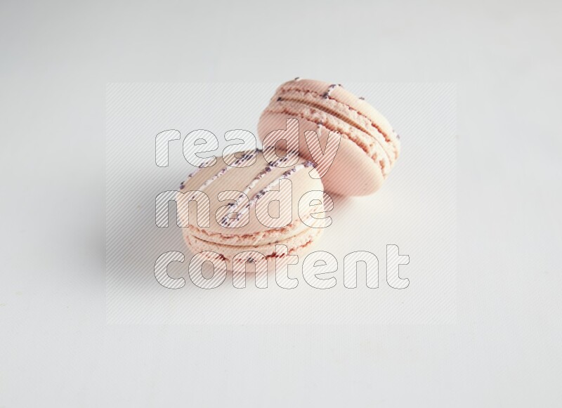 45º Shot of two pink orange blossom macarons on white background