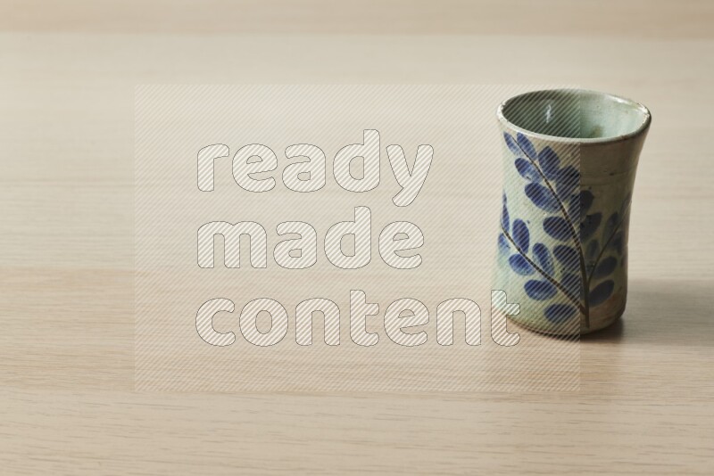 A pottery cup on light wooden background