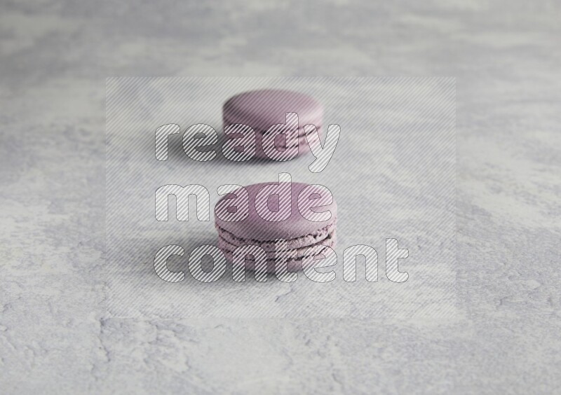 45º Shot of two Purple Blueberry macarons  on white  marble background
