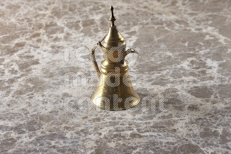 A metal turkish pot on beige marble background