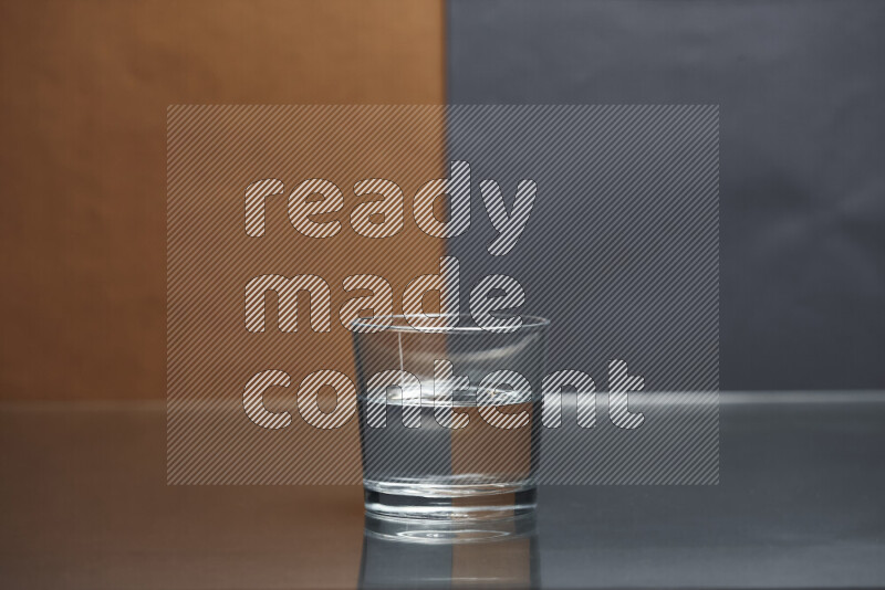 The image features a clear glassware filled with water, set against brown and dark blue background