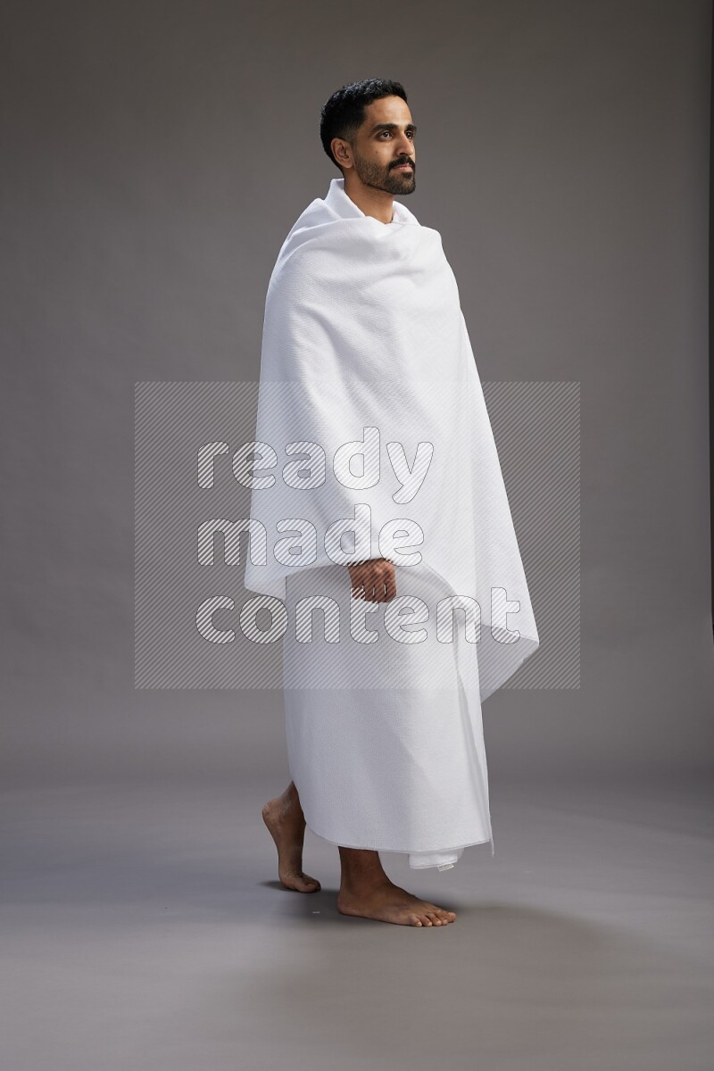 A man wearing Ehram Standing Interacting with the camera on gray background