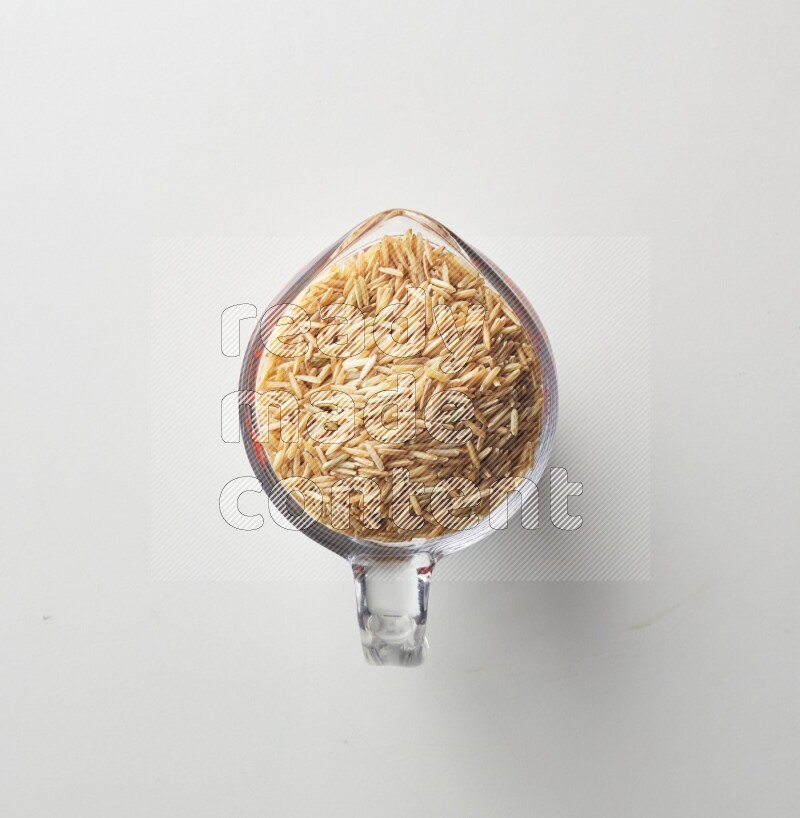 Top-view shot of long grain brown rice in a container on white background