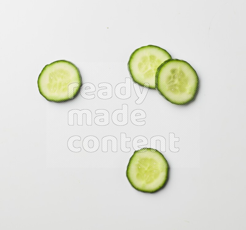 Multiple cucumber slices on white background