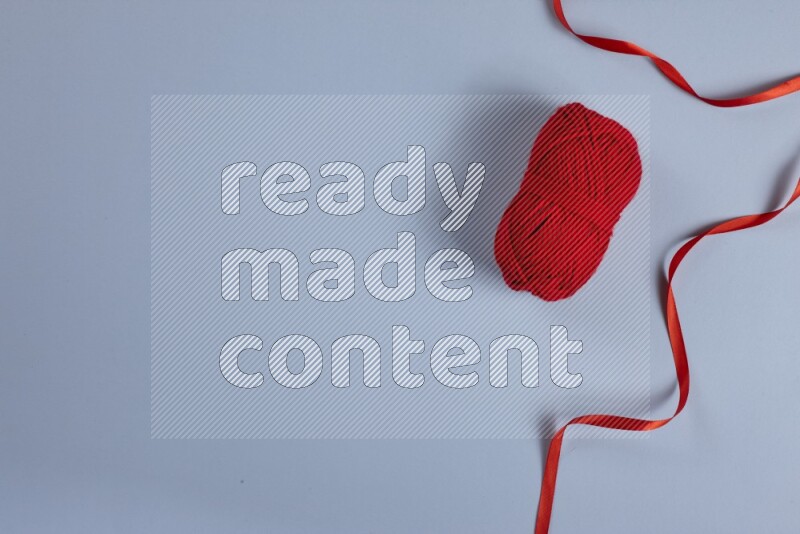 مجموعة من أدوات الخياطة والتفصيل حمراء اللون على خلفية زرقاء