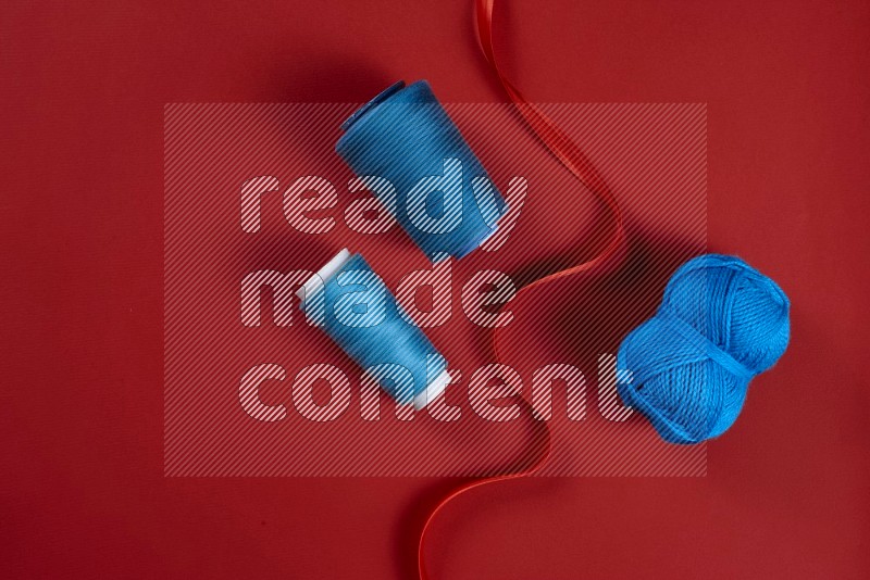 Blue sewing supplies on red background
