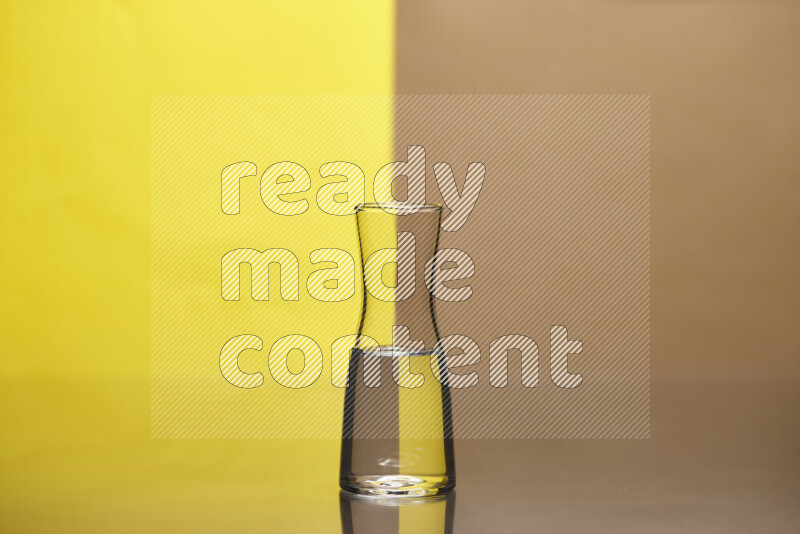 The image features a clear glassware filled with water, set against yellow and beige background