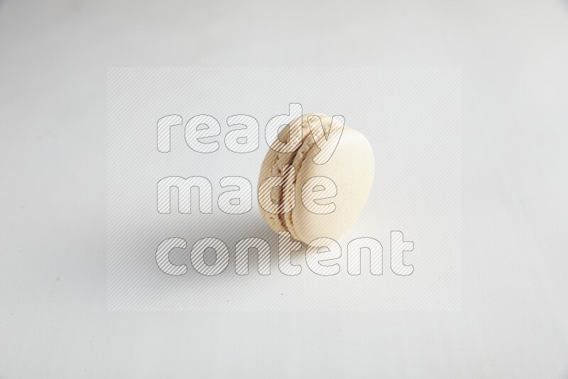 45º Shot of White Caramel fleur de sel macaron on white background