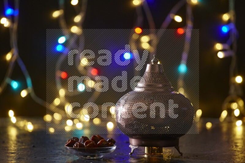 A traditional ramadan lantern surrounded by glowing fairy lights in a dark setup