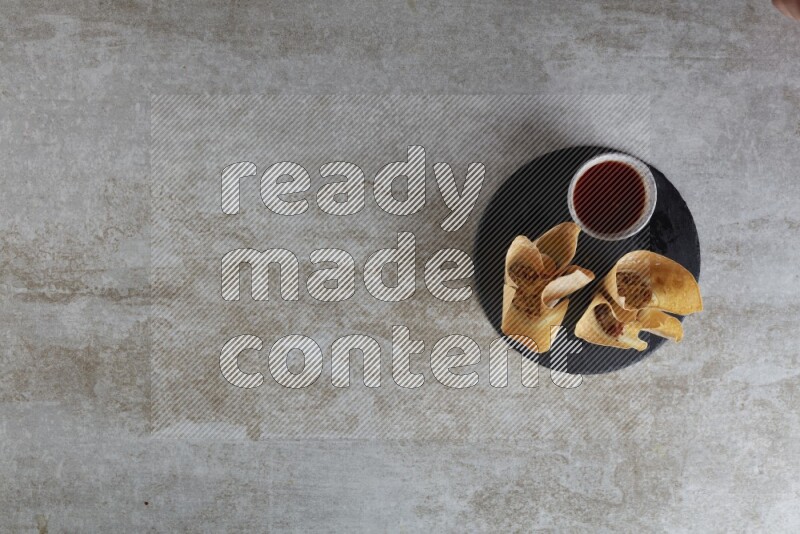 wonton cups with soy sauce ramkin on circle slate on grey textured counter top