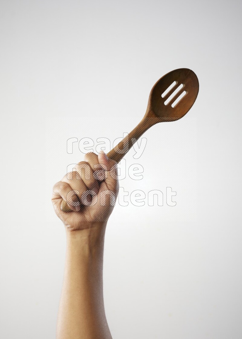 Male Hand Holding Wooden colander spoon  on white background