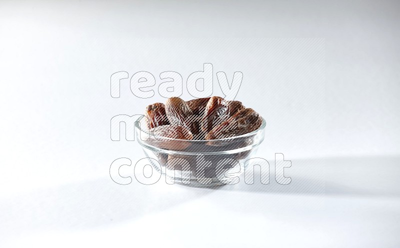 A glass bowl full of dried dates on a white background in different angles