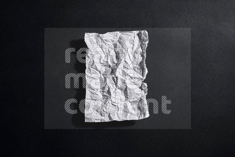 Crumpled notebook sheet on black background