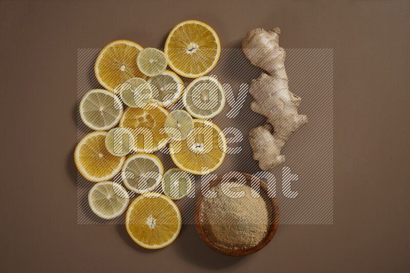 Fresh ginger root with different ingredients such as lemon, orange, honey, ground ginger on beige baackground