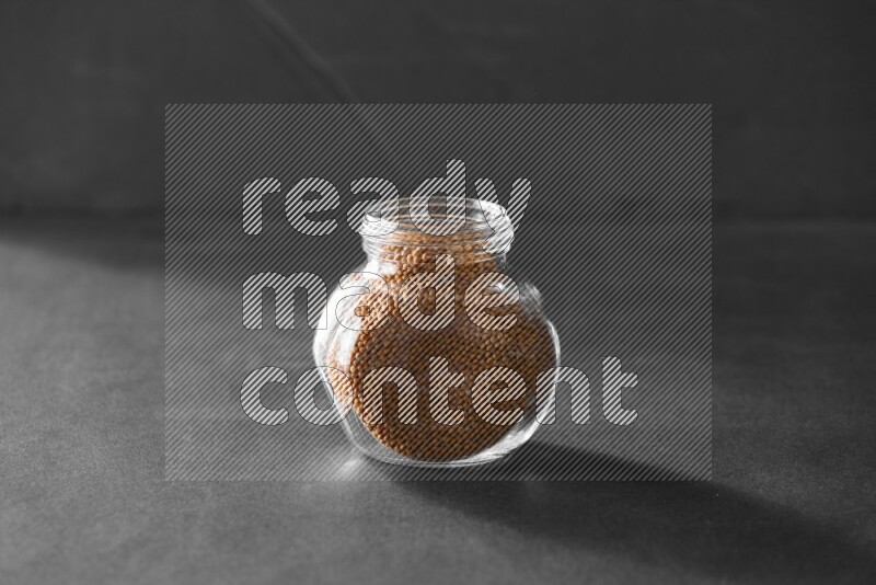 حبوب الخردل في وعاء زجاجي علي خلفية سوداء