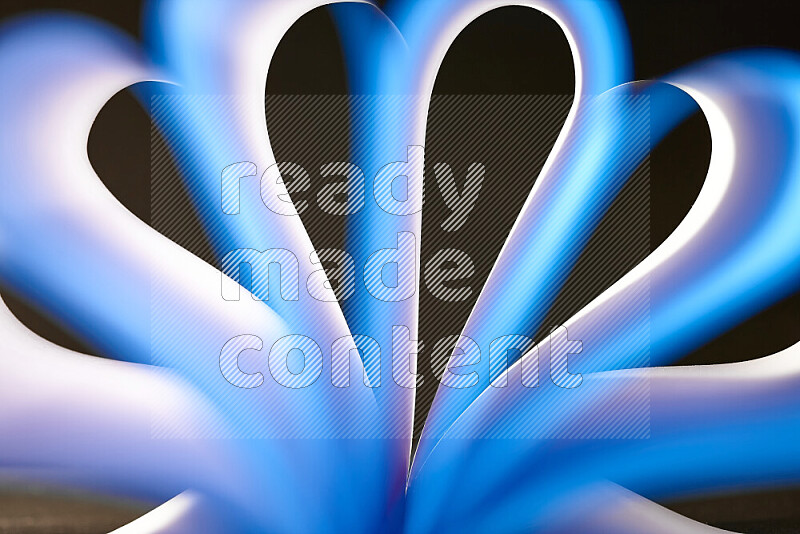 An abstract art piece displaying smooth curves in white and blue gradients created by colored light