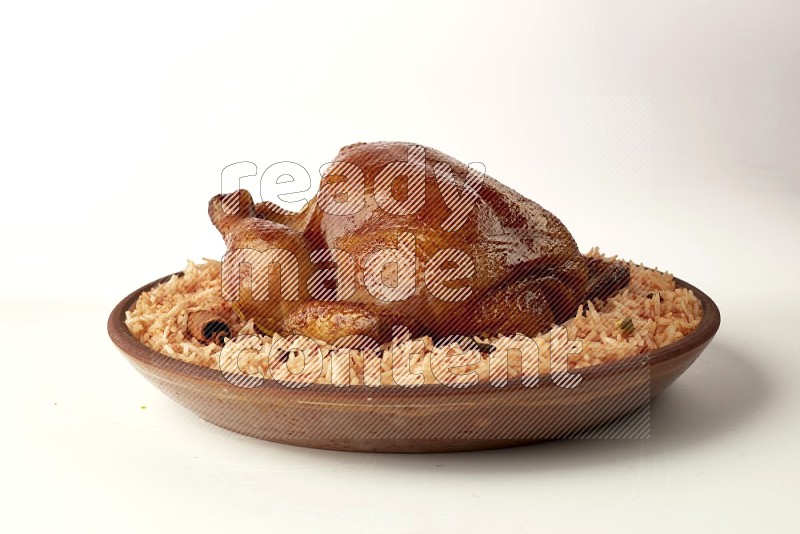 red basmati Rice with whole roasted chicken on a pottery plate direct on white background