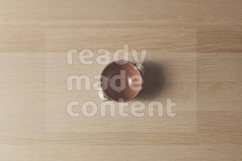 A multicolored pottery pot on light wooden background
