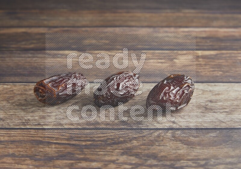 three madjoul dates on a wooden background