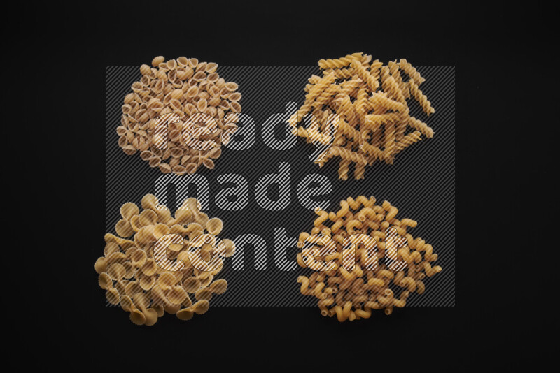 Different pasta types in bunches on black background