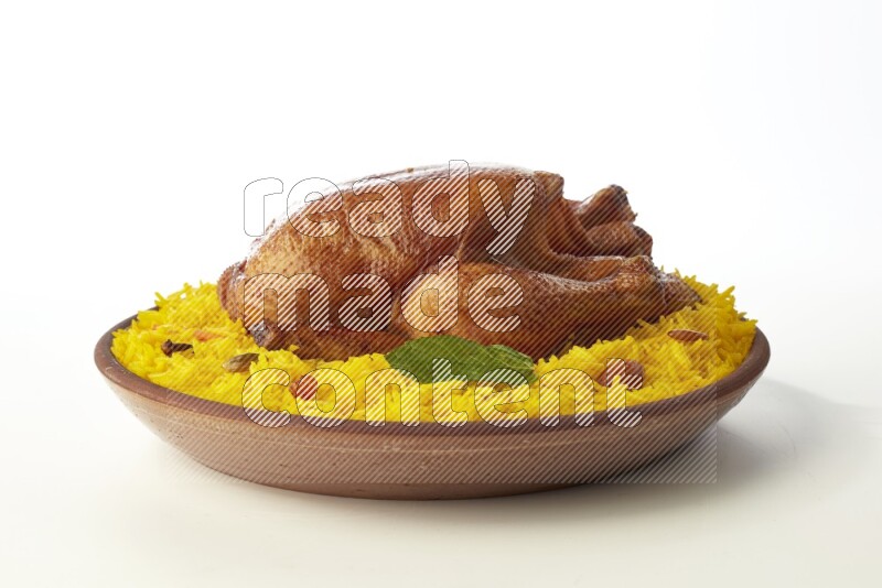 yellow basmati Rice with whole roasted chicken  on a pottery plate  direct  on white background