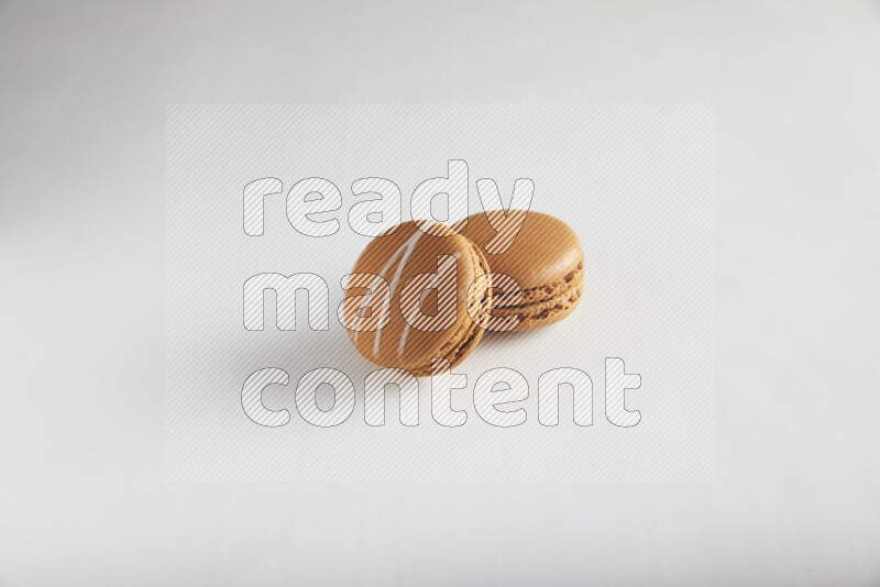 45º Shot of of two assorted Brown Irish Cream, and Brown Maple Taffy macarons  on white background