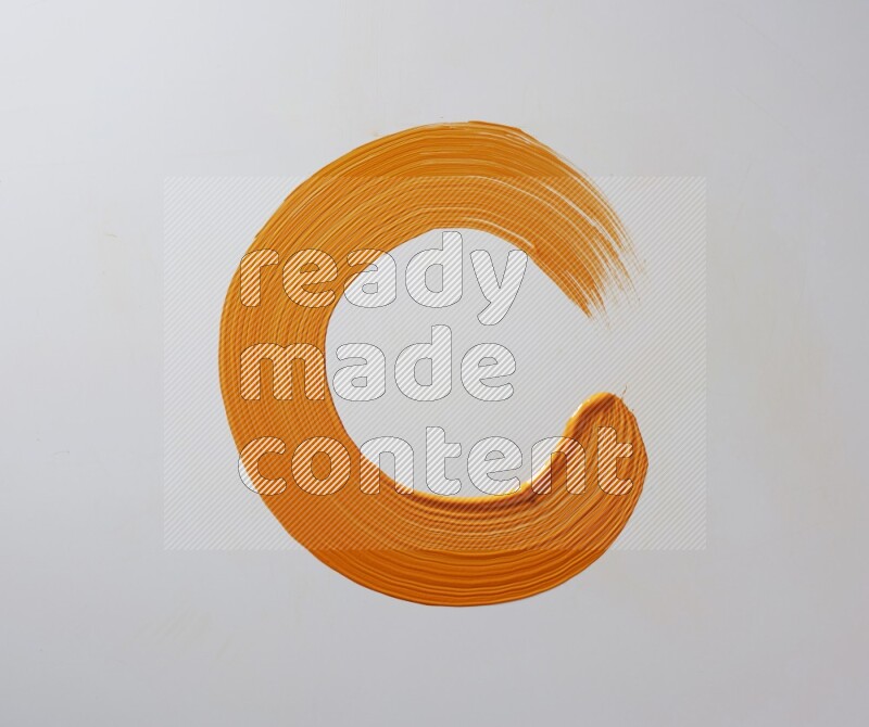 An orange circular painting brush stroke on white background